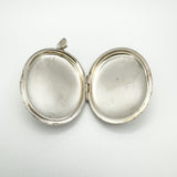 Open vintage silver locket showing inner compartments without liners