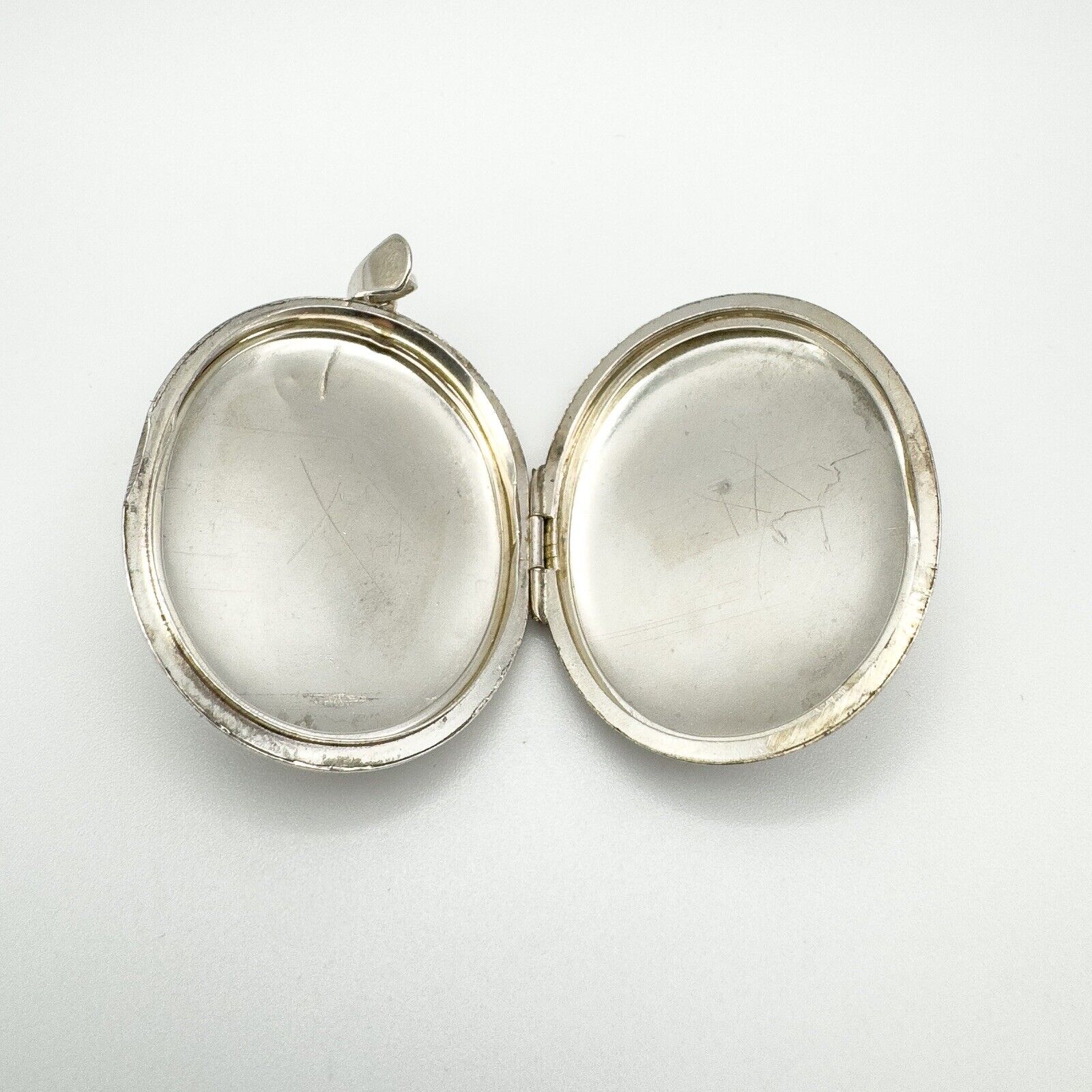 Open vintage silver locket showing inner compartments without liners