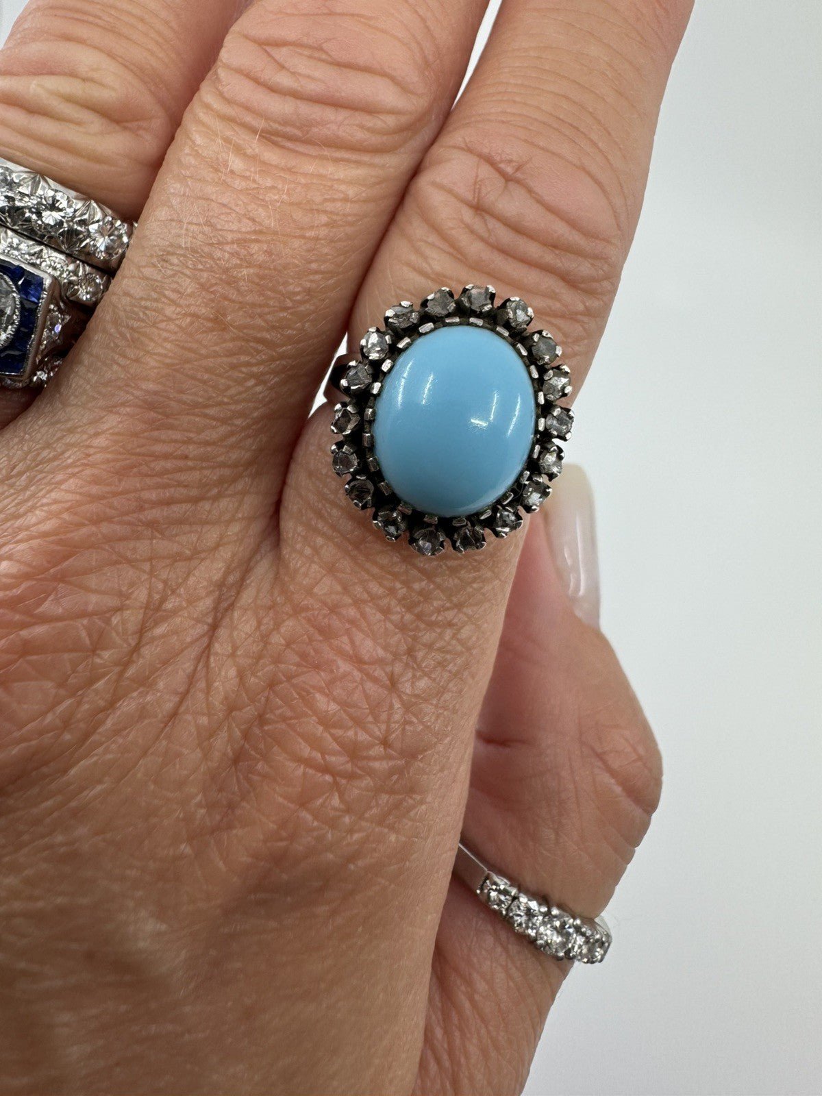Large sterling silver turquoise and diamond halo ring shown worn on the hand