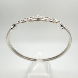 Side view of sterling silver bangle with twisted knot leading to clasp