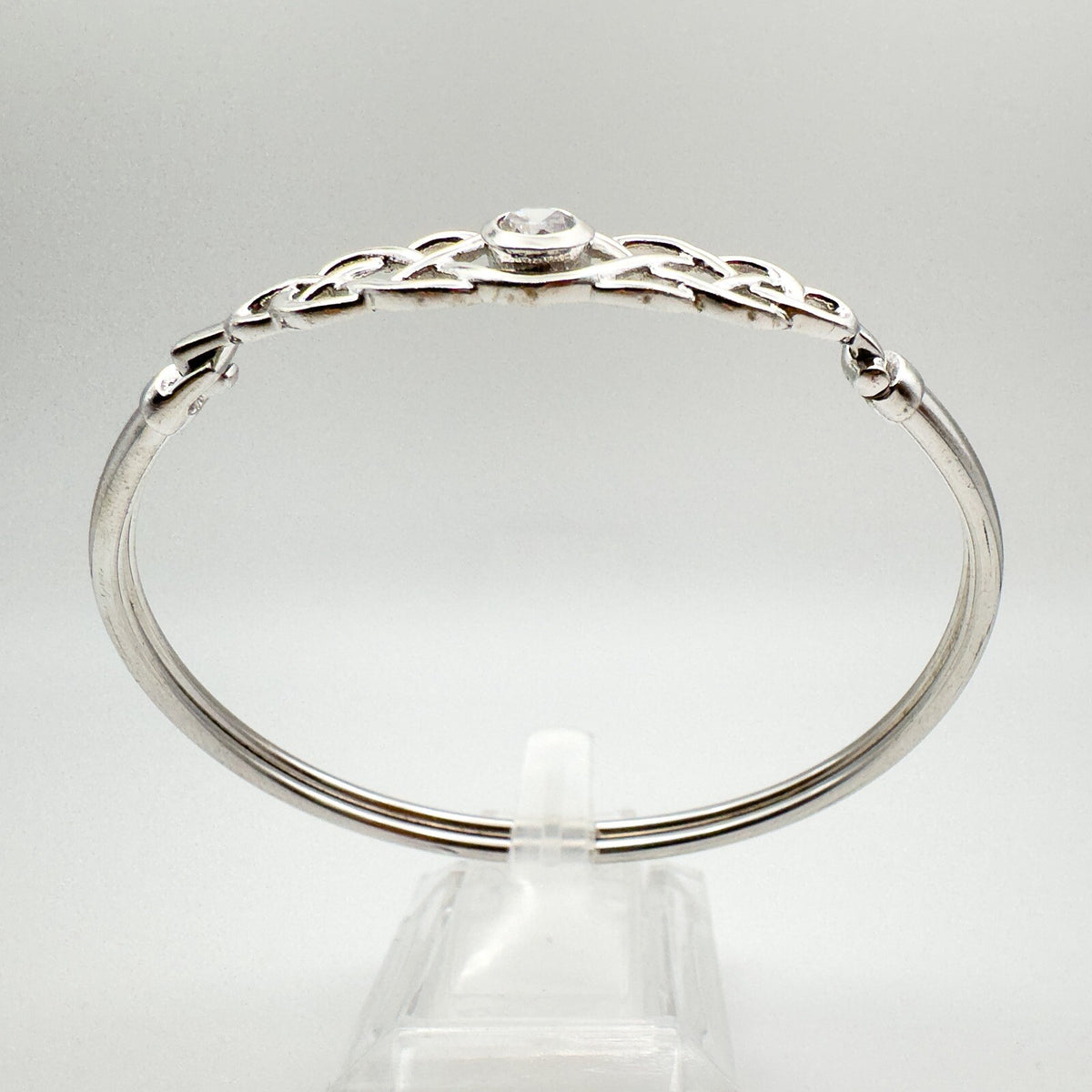 Side view of sterling silver bangle with twisted knot leading to clasp