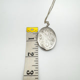 Height of engraved sterling silver locket shown next to tape measure