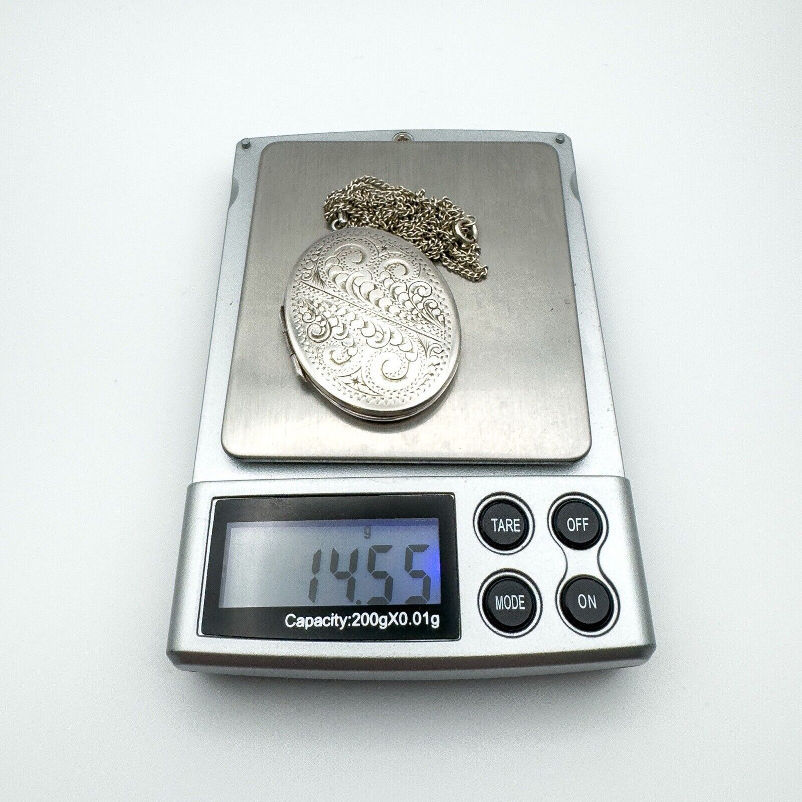 Full locket and chain weighing 14.55g displayed on digital jewellery scale