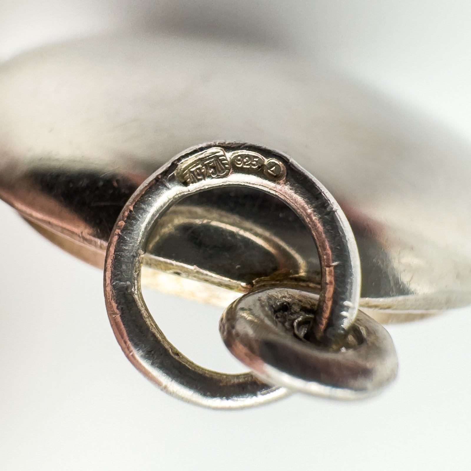 Close-up of CME, 925, and triangle import marks on locket bail