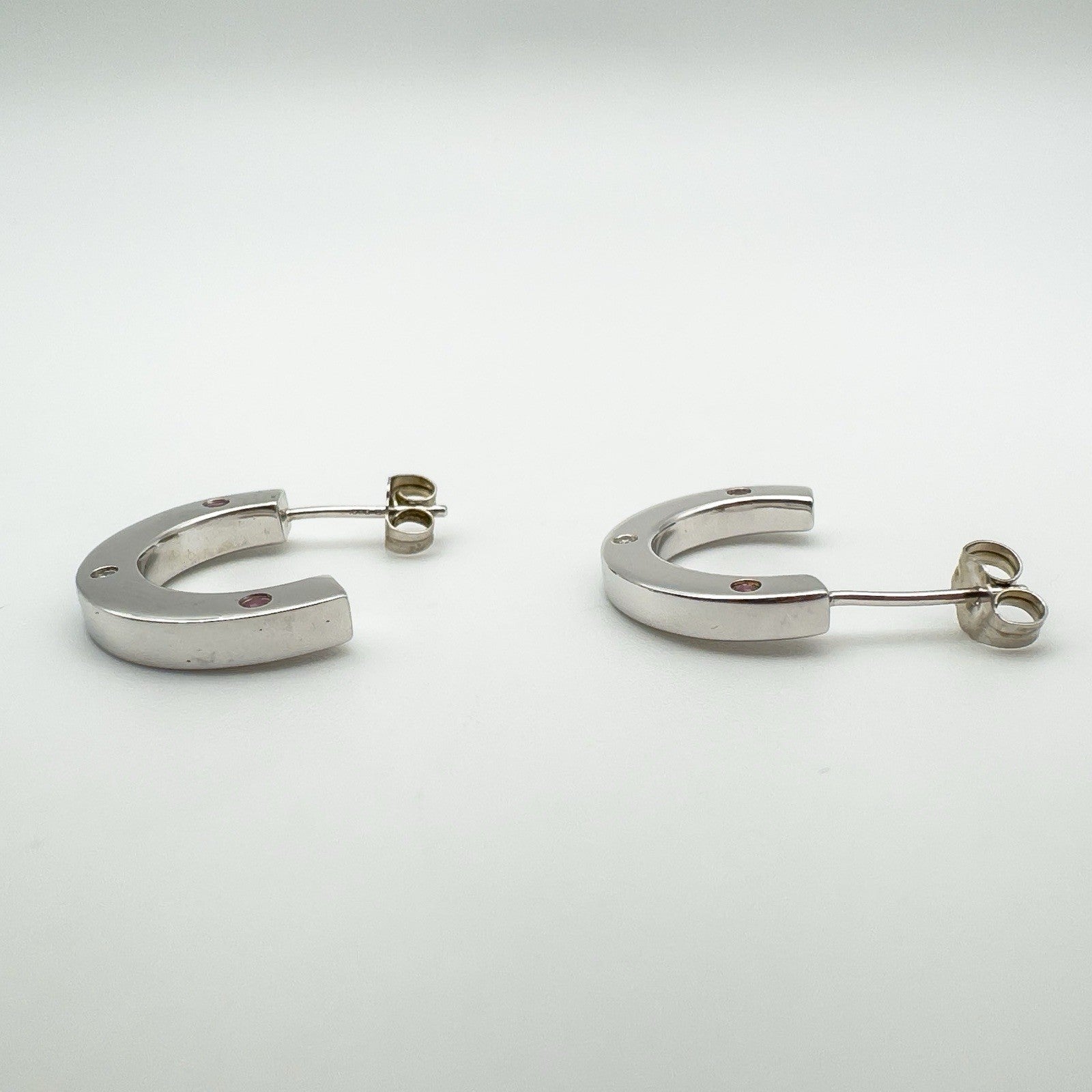 Low angle side view displaying the thickness and shine of the silver hoop earrings