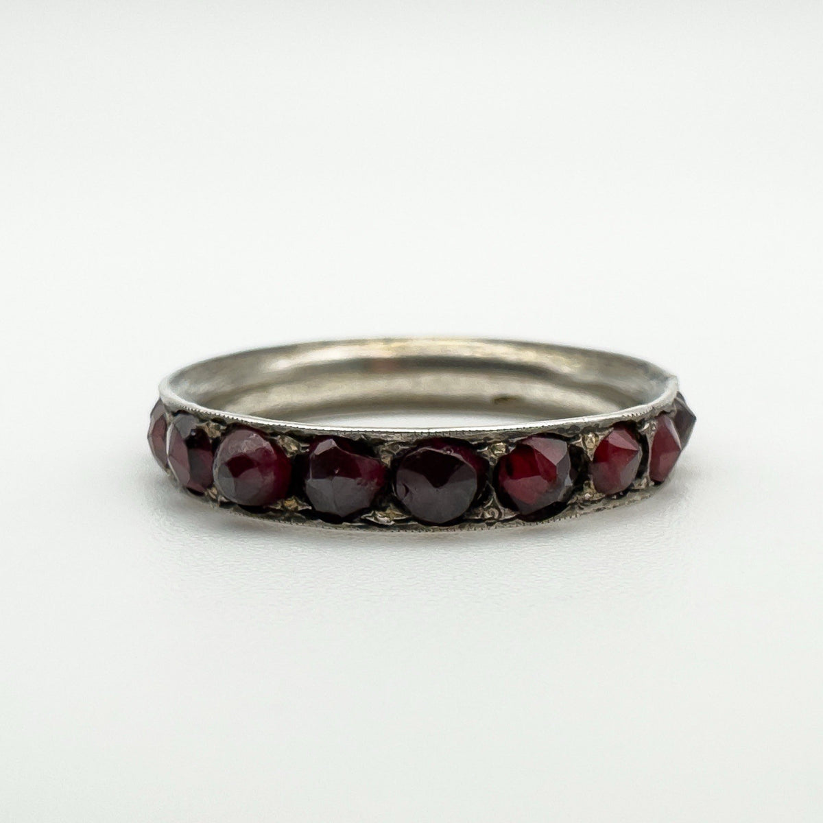 Low angle close-up showing garnet settings and silver ring profile