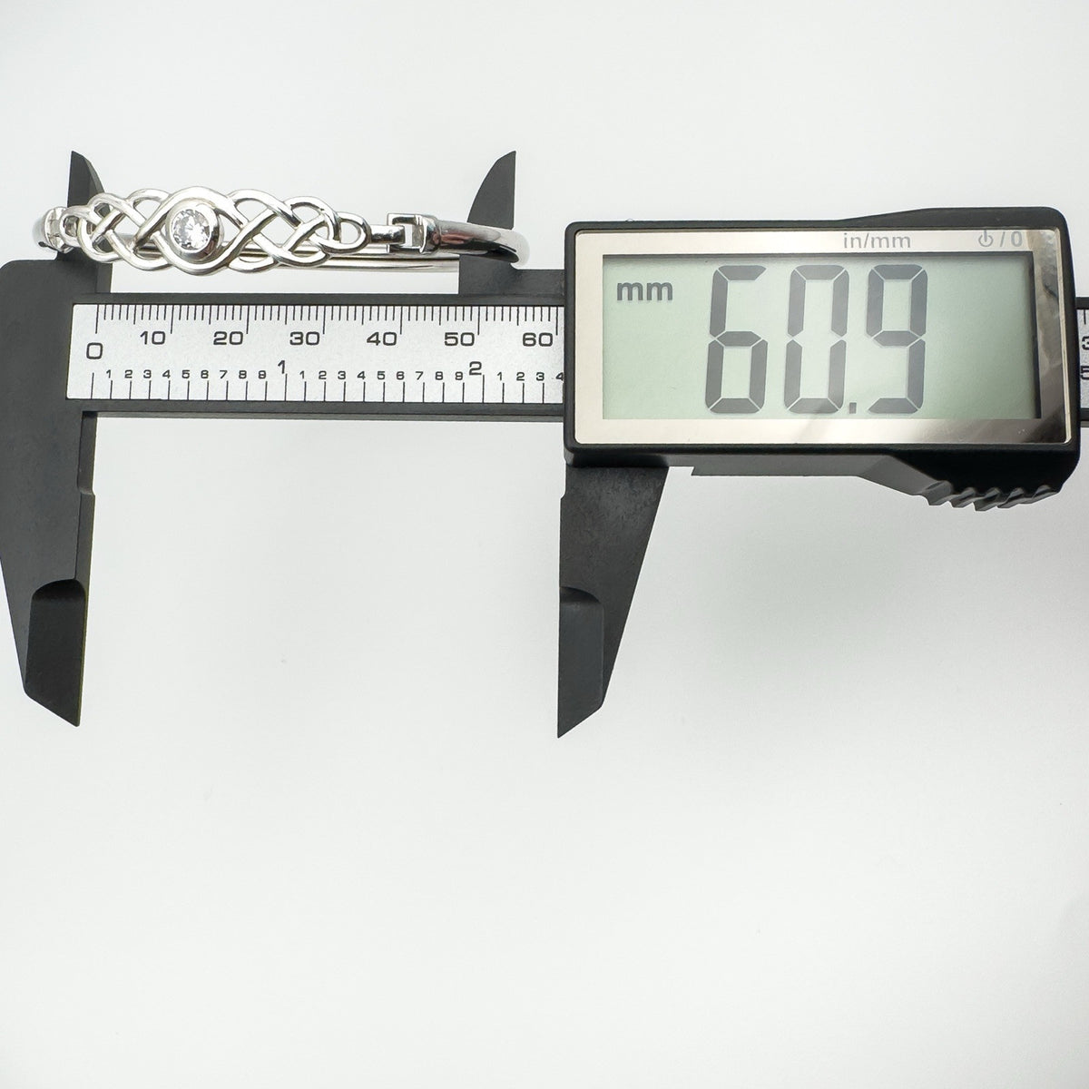 Digital caliper showing inside width measurement of bangle at 60.9mm