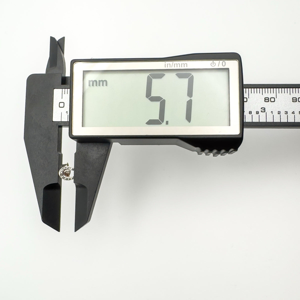 Digital caliper showing horseshoe earring height at 5.7mm