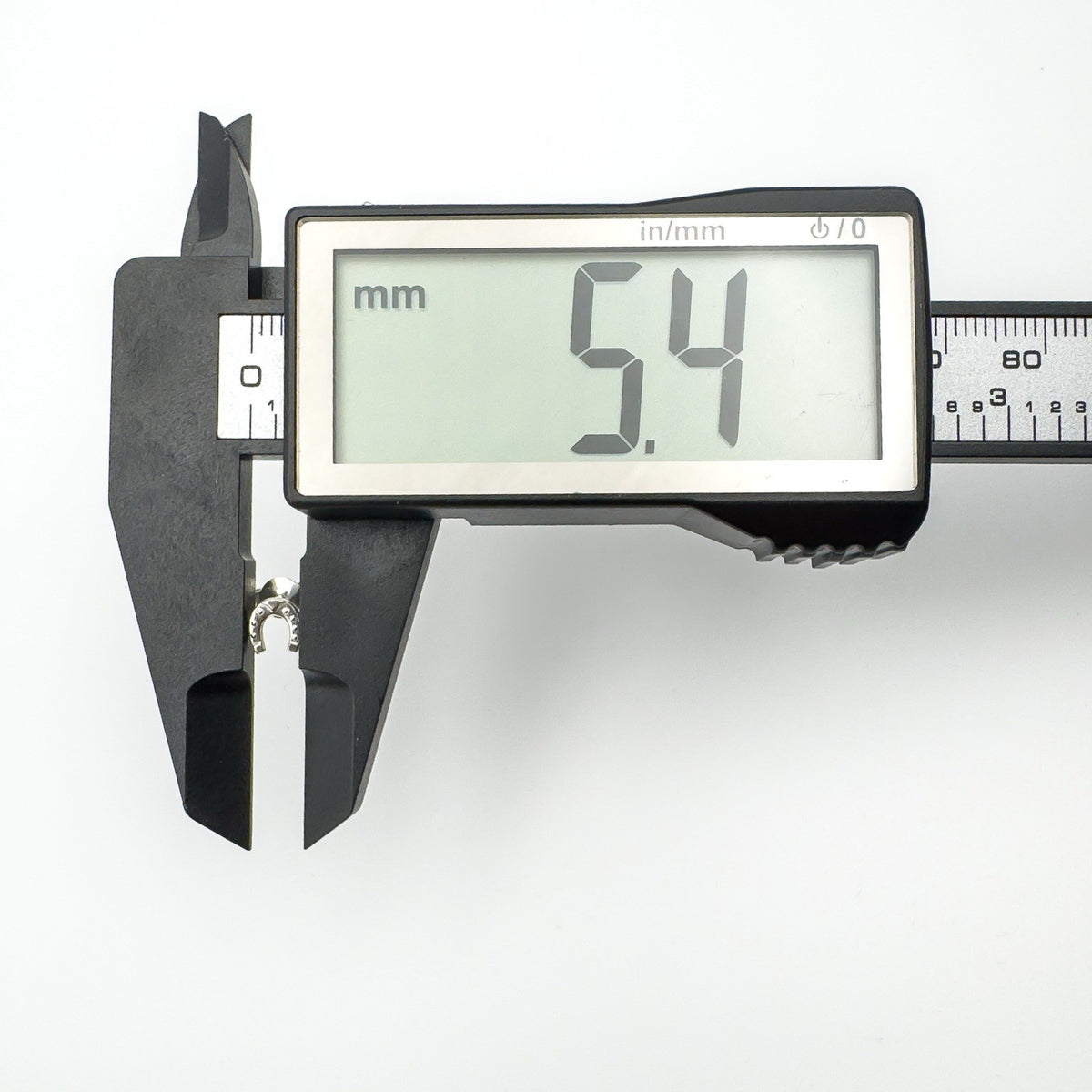 Digital caliper showing horseshoe earring width at 5.4mm