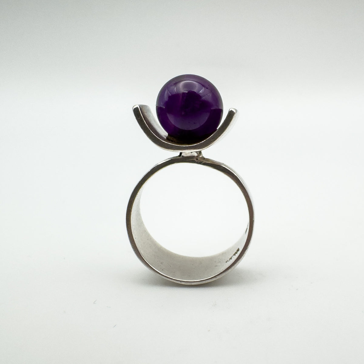 Front view of vintage modernist ring with deep amethyst ball in sterling silver
