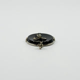 Low front view of vintage black onyx bow pendant showing raised bow detail and oval onyx.