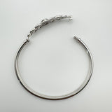 Image of bangle laid flat with open hook clasp for fastening detail
