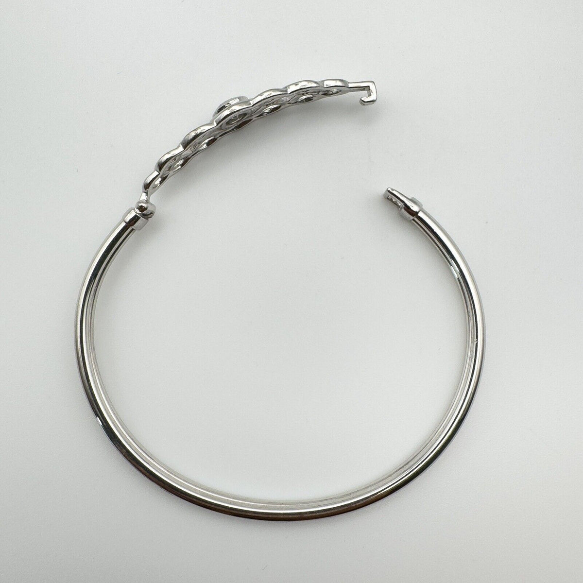 Image of bangle laid flat with open hook clasp for fastening detail