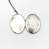 Outside of vintage oval silver locket showing hallmark on one side