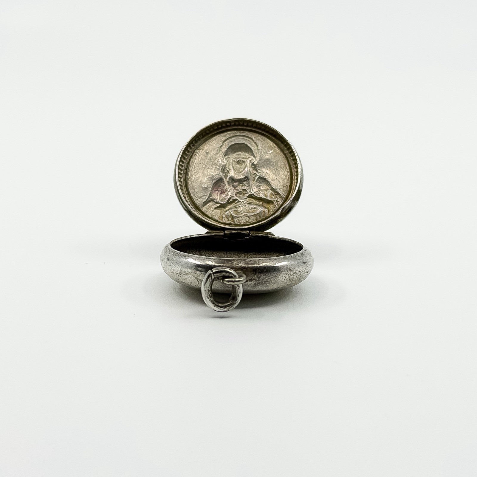 Open sterling silver Virgin Mary photo locket pendant showing the interior and jump ring.