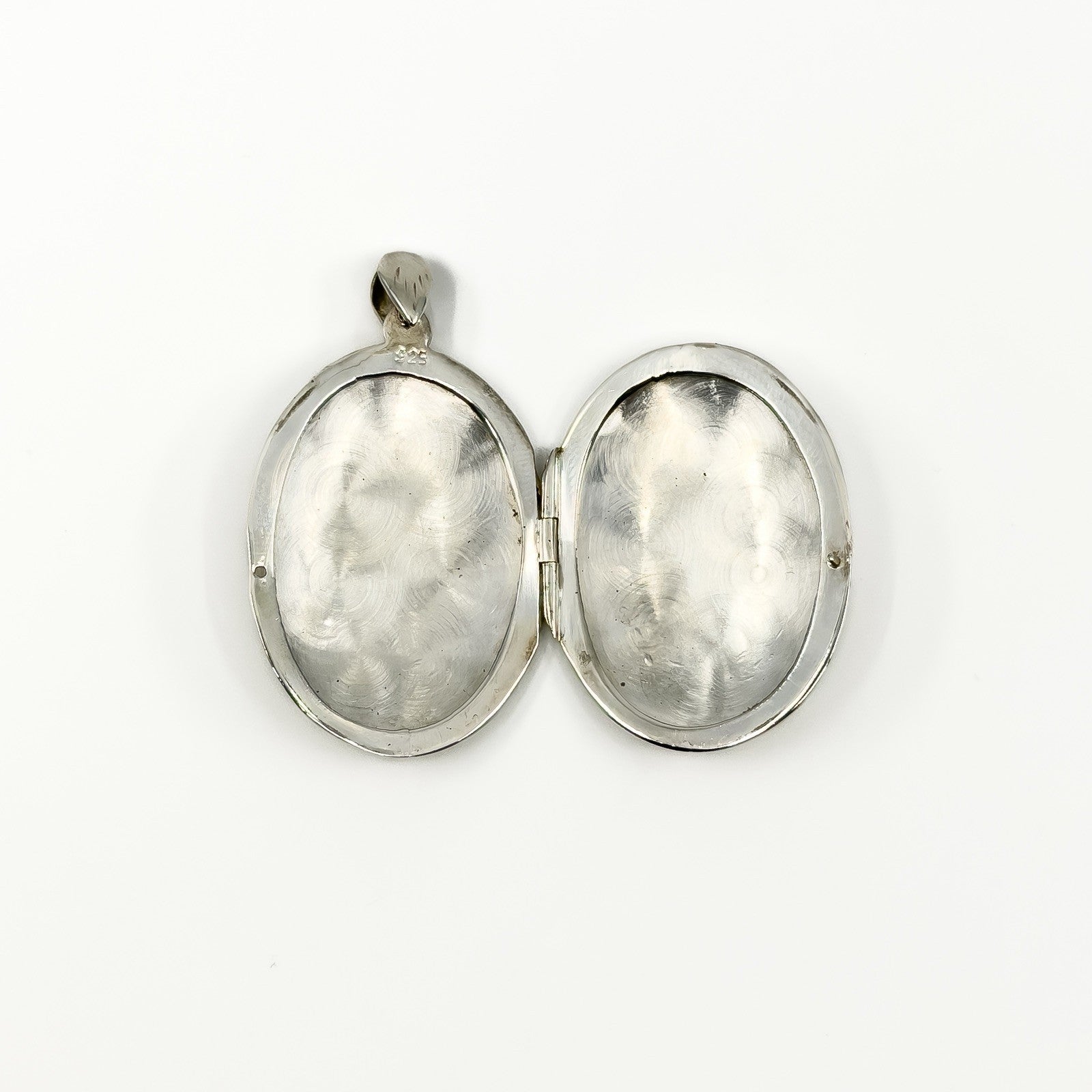 Open sterling silver oval photo locket showing the plain interior and hinge