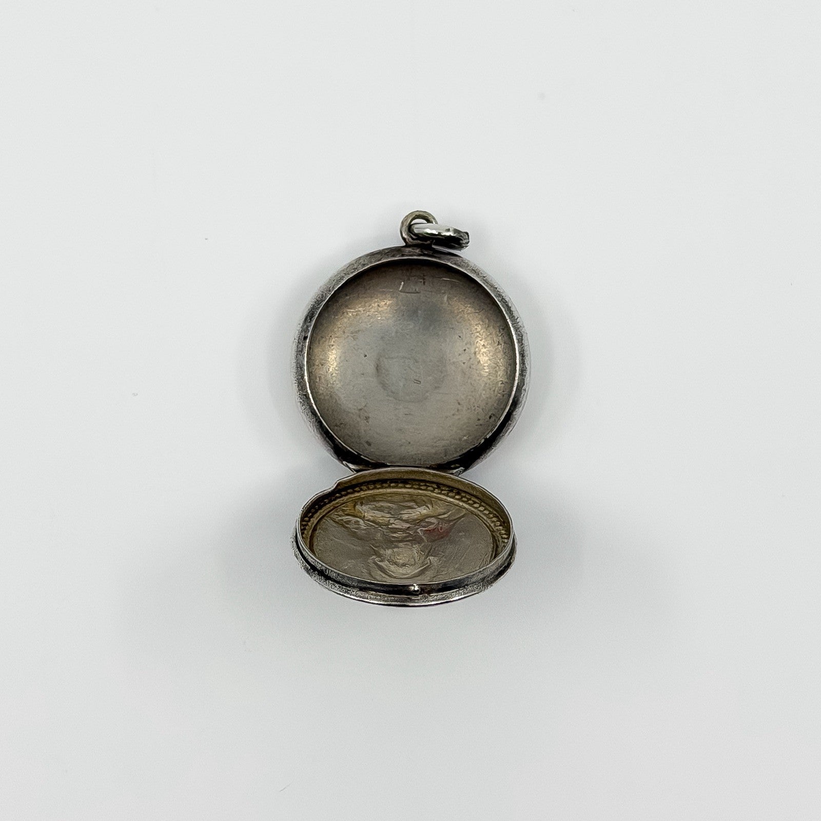 Open vintage sterling silver photo locket pendant showing space inside for small photos.