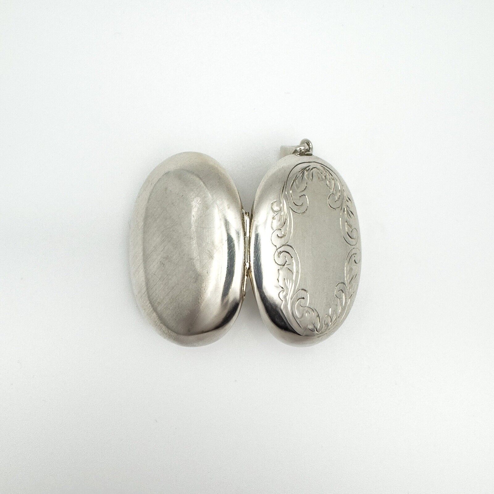 Chunky sterling silver locket opened to show front engraving and plain back