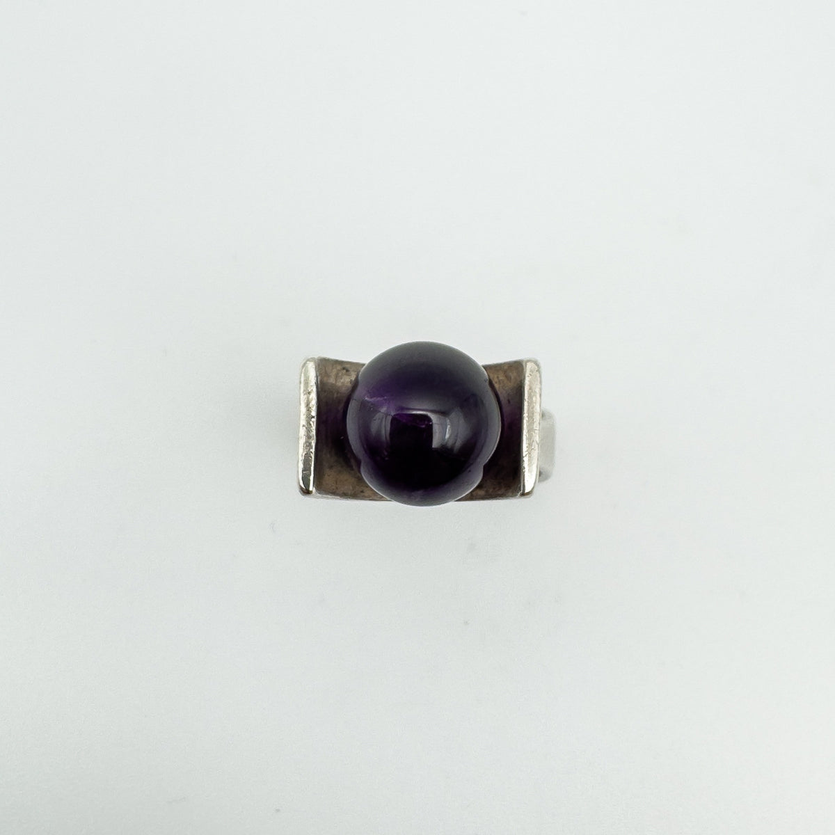 Overhead view showing amethyst ball set between thick silver shoulders
