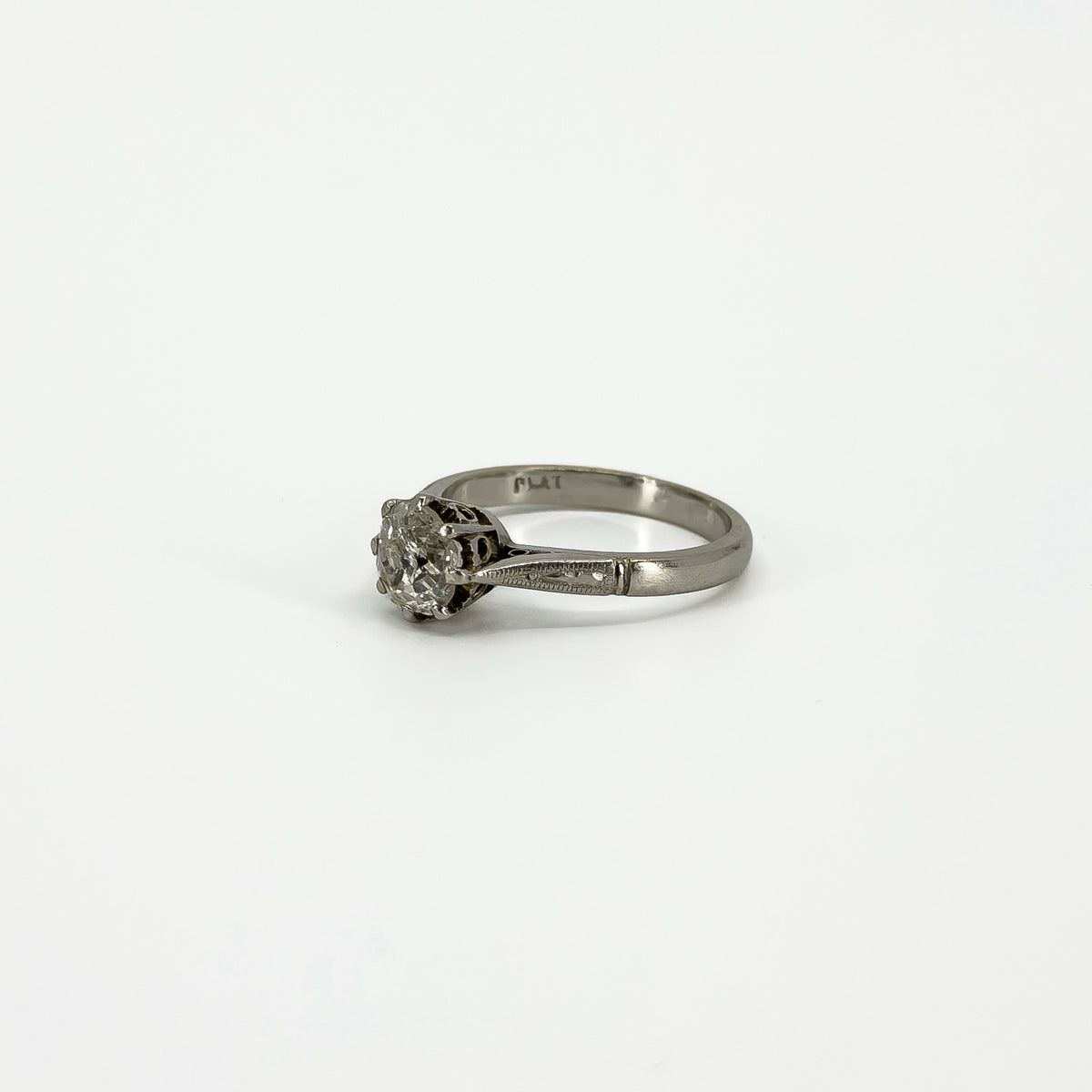 Side view of antique platinum diamond solitaire ring with PLAT stamp visible inside the band