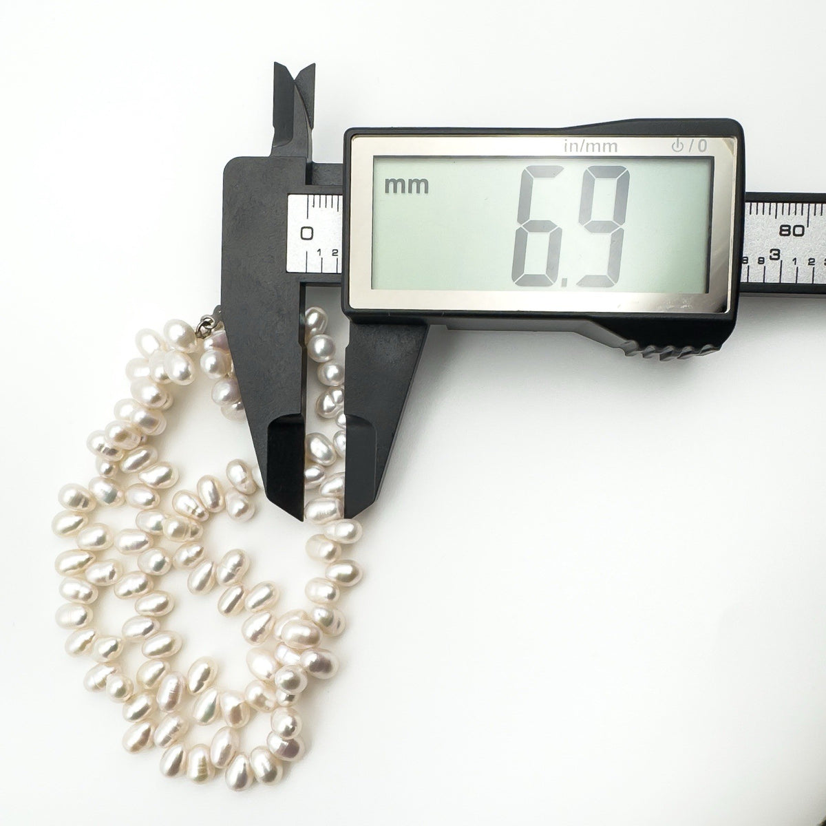 Measuring baroque pearl diameter at 6.9mm with digital calliper