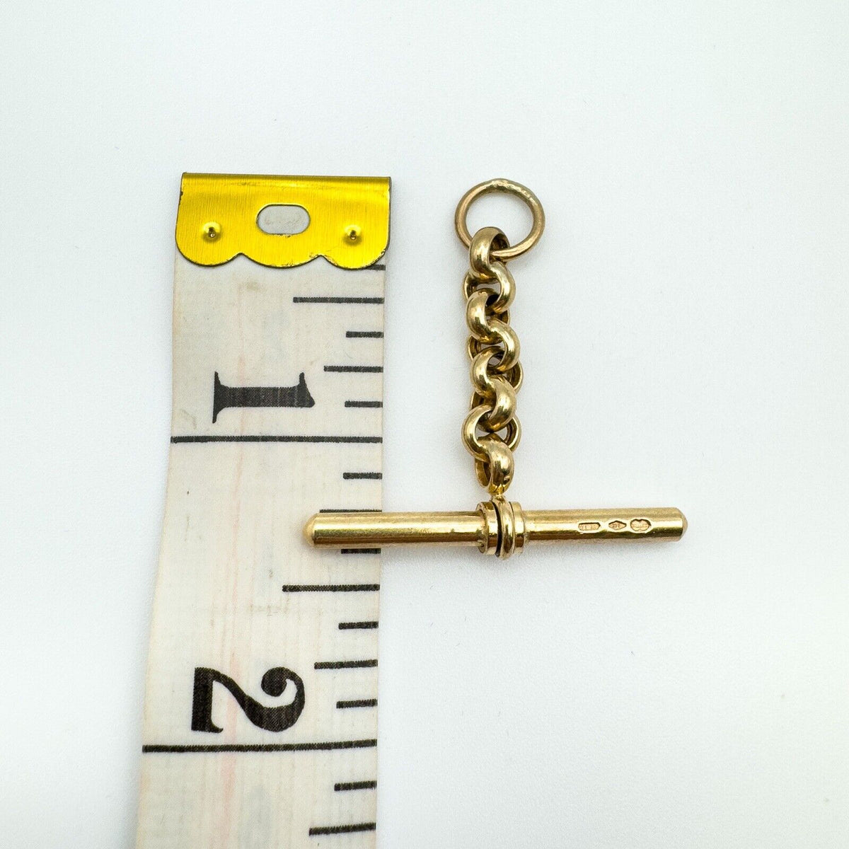 Vintage gold T-bar pendant with belcher link shown against tape for scale