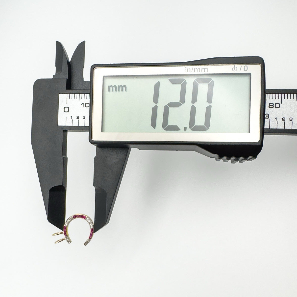 Digital caliper showing horseshoe pendant diameter at 12mm