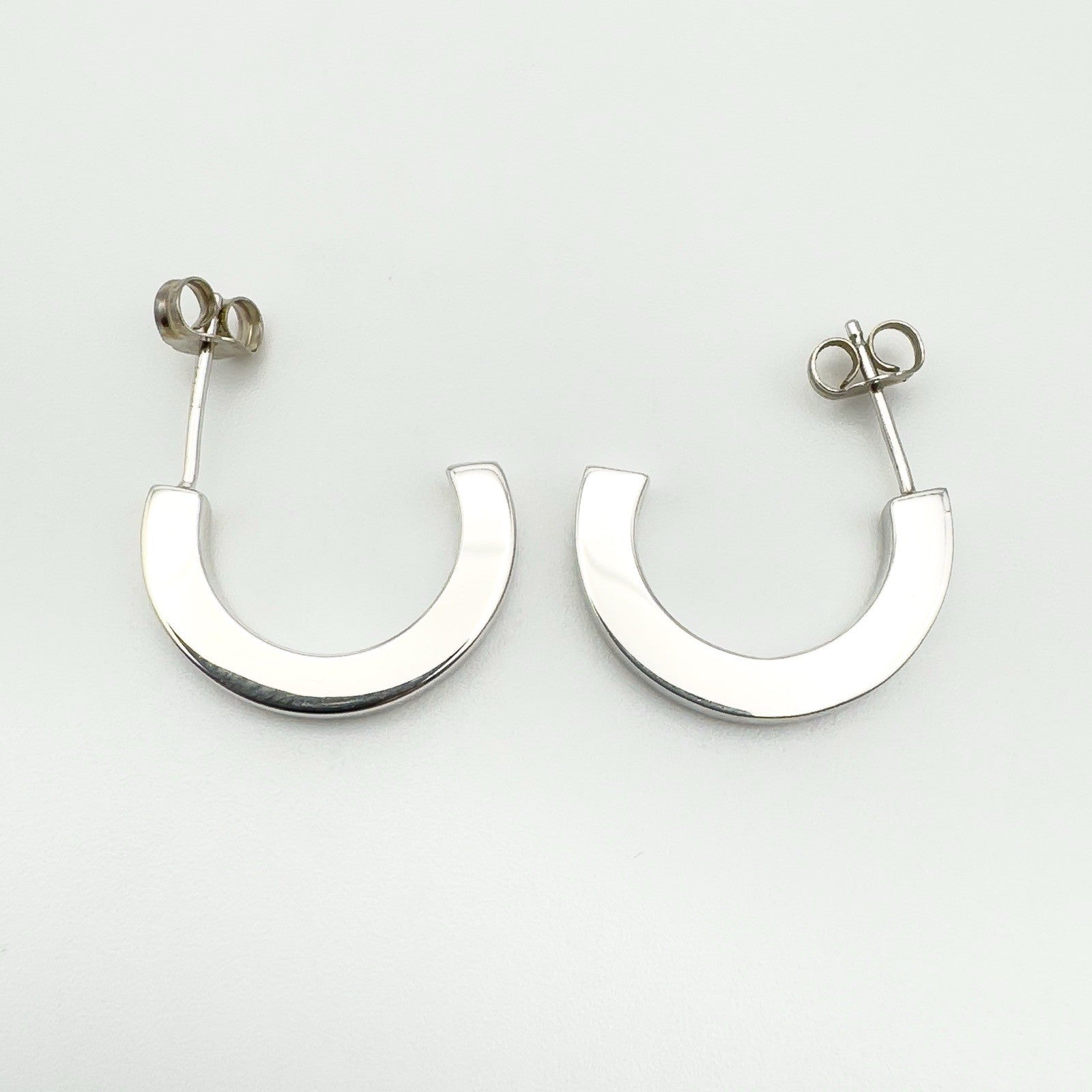 Reverse side of earrings showing smooth polished silver backs without stones