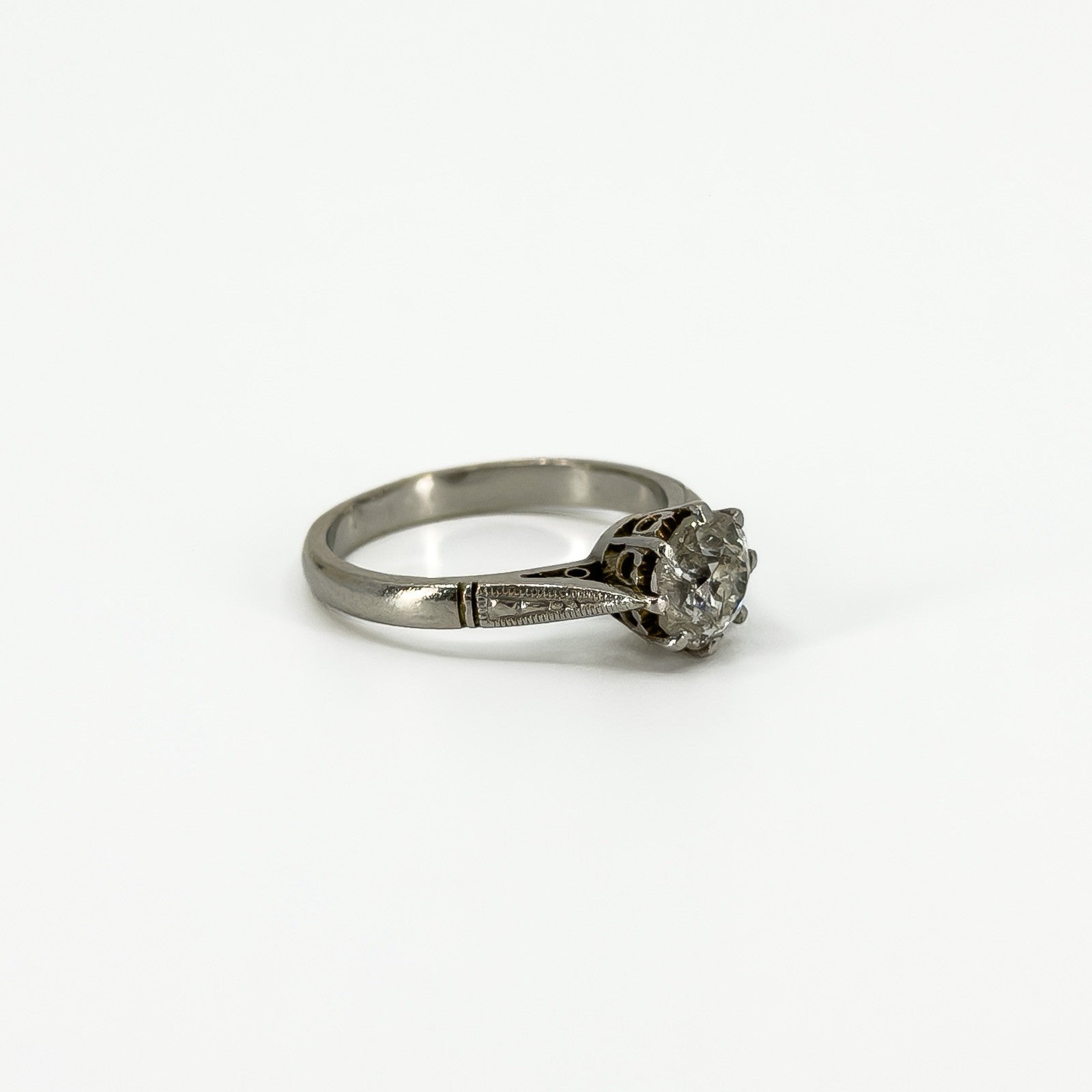 Side profile of antique platinum old-cut diamond solitaire ring with engraved shoulder detail