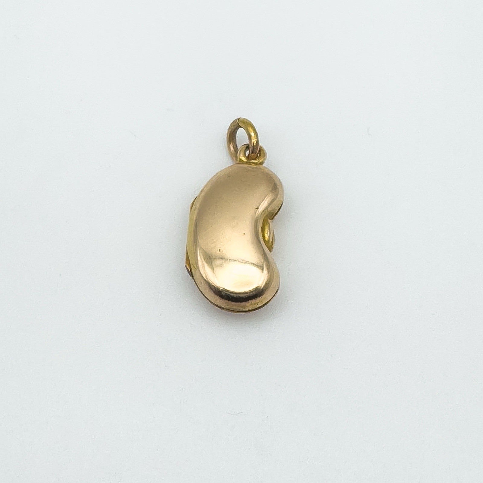 Vintage kidney bean charm in 18ct yellow gold with smooth reflective surface