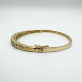 Side angle showing secure clasp on oval emerald and diamond bangle
