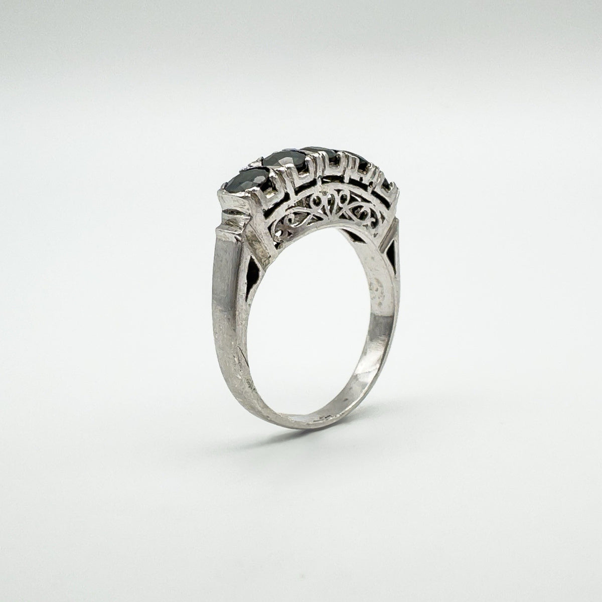 Angled side view of filigree shoulder detail and sapphire setting