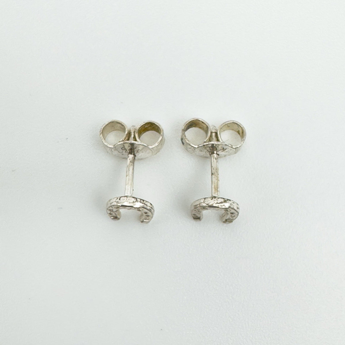Back view of sterling silver horseshoe earrings with posts and scrolls