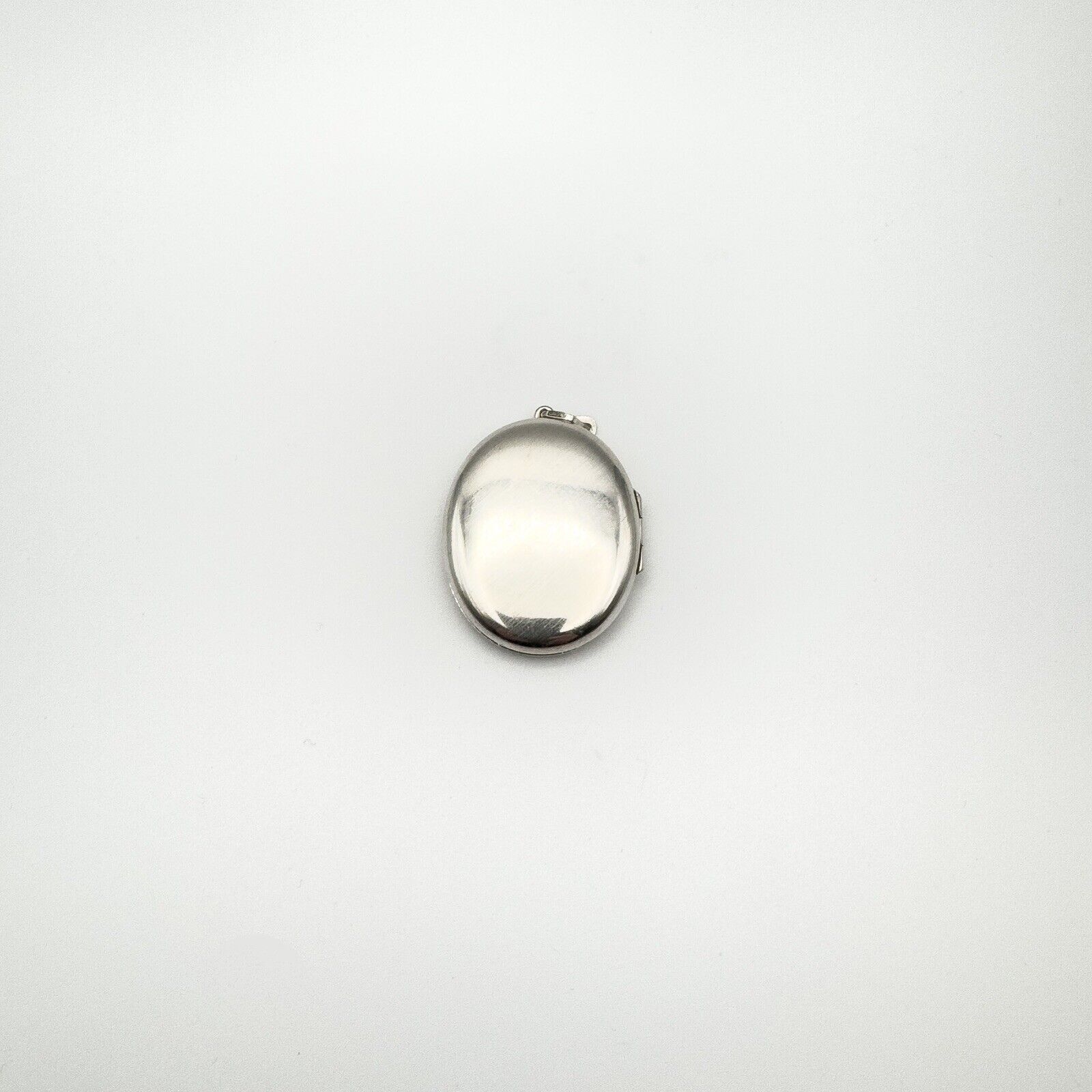 Back of vintage sterling silver locket with smooth polished surface