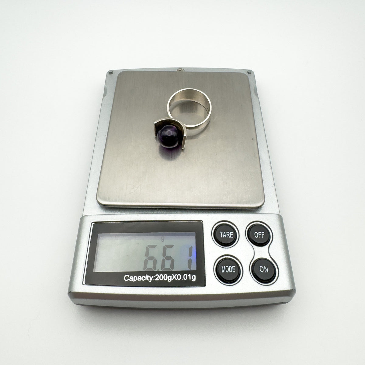 Sterling silver amethyst ring shown weighing 6.6g on digital scale