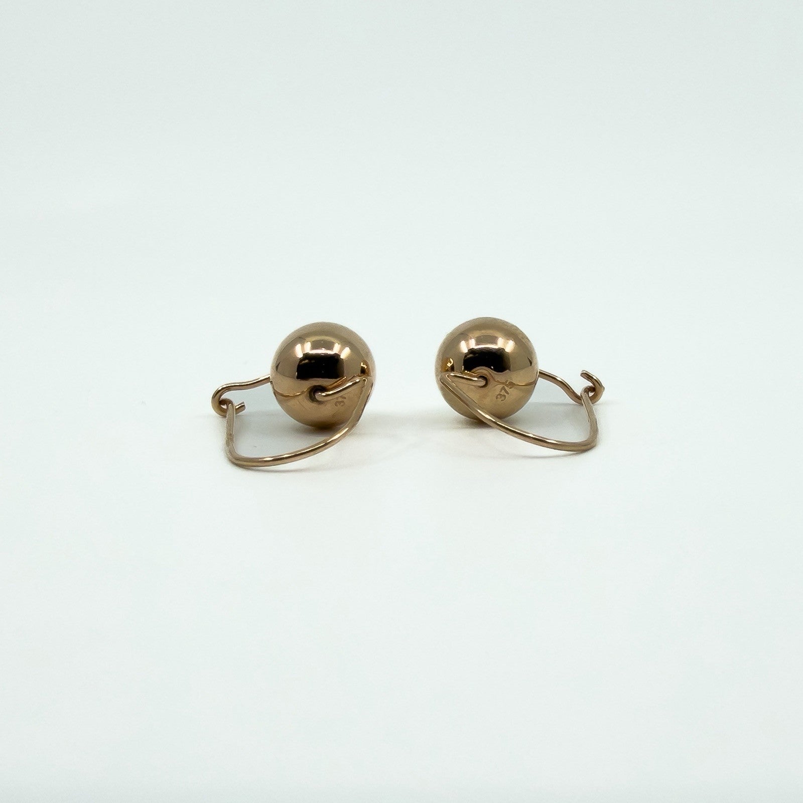 Reverse view of 9ct rose gold ball hook drop earrings showing curved wire fittings
