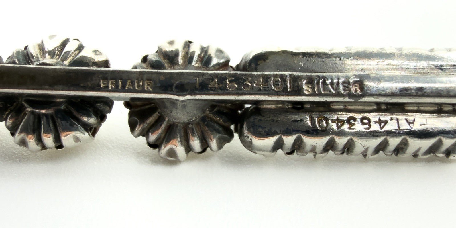 Macro photo of the SILVER stamp on the antique bar brooch, with faint patent number visible.
