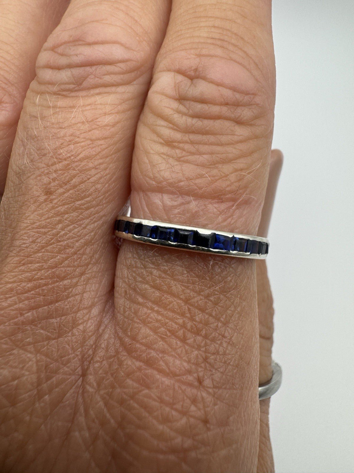 18ct white gold eternity ring worn with sapphires facing up on finger