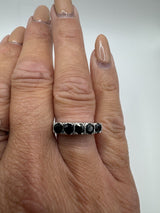 Vintage sterling silver ring with dark blue sapphires shown worn on finger