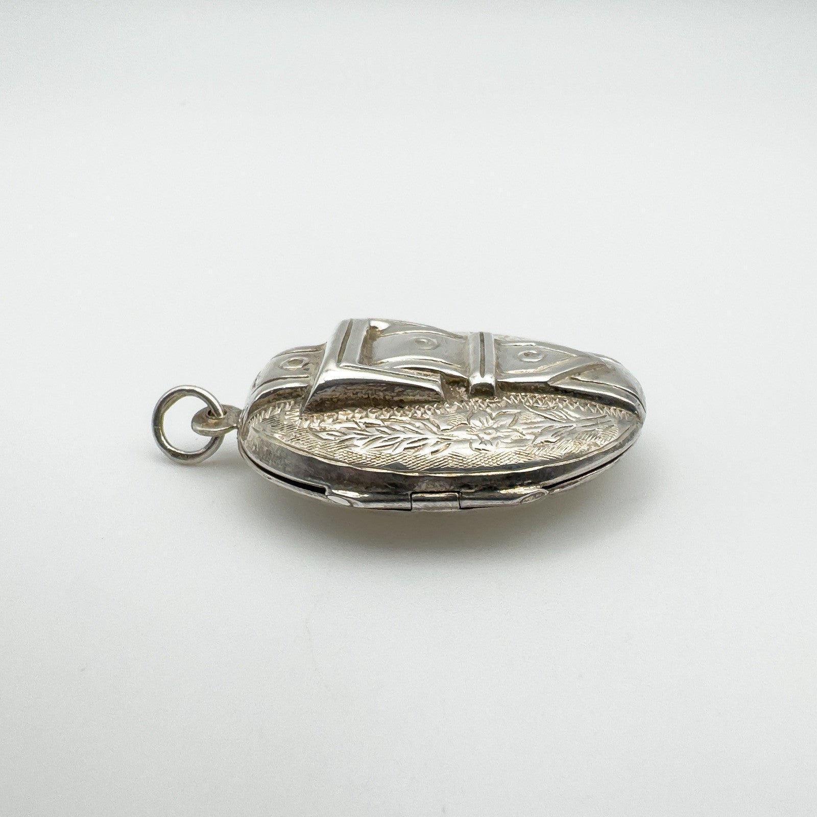 Chunky sterling silver buckle locket showing depth and engraved detail