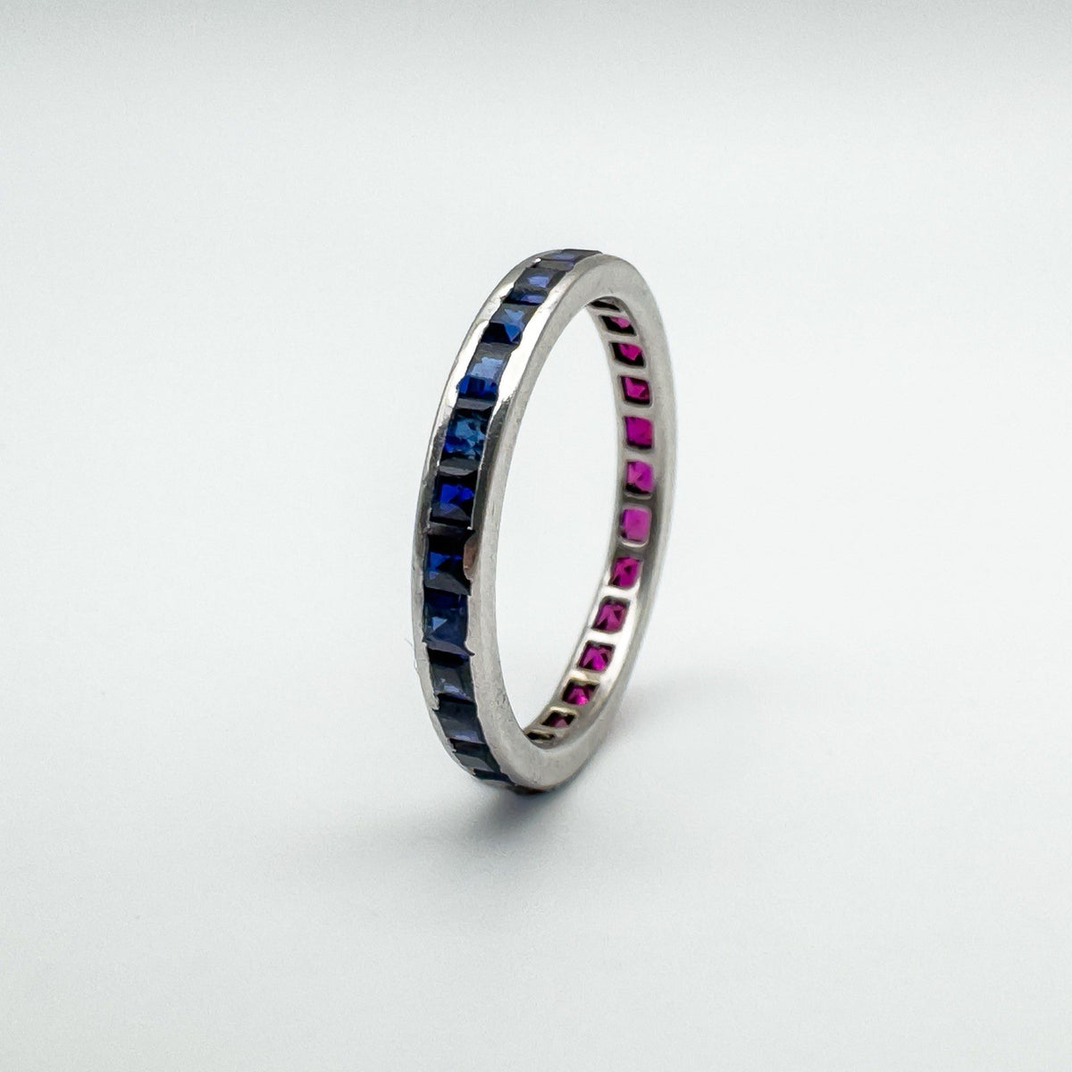 Side profile of white gold stacking ring showing blue sapphires in channel setting