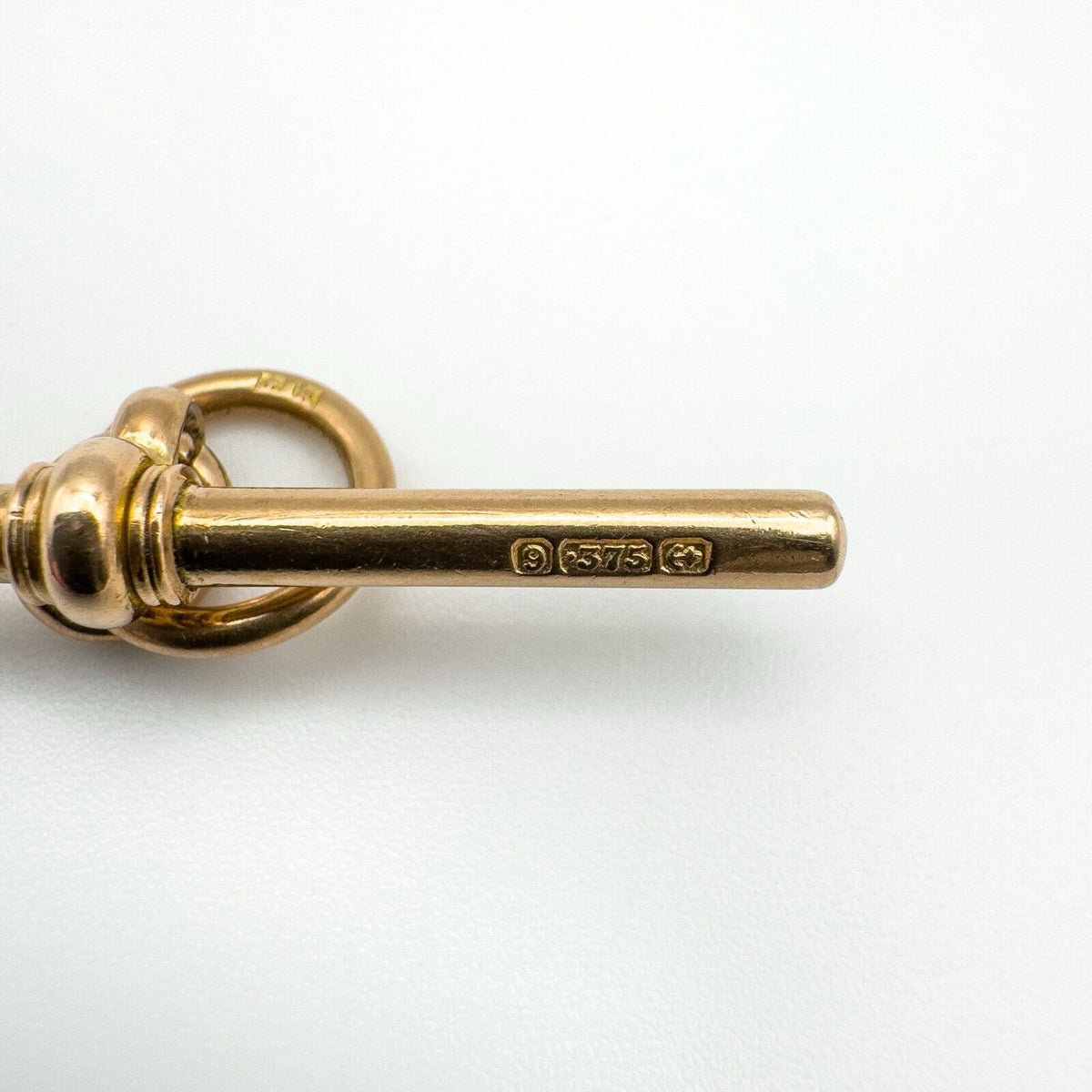 Side view of vintage 9ct gold T-bar with visible 375 and maker hallmarks