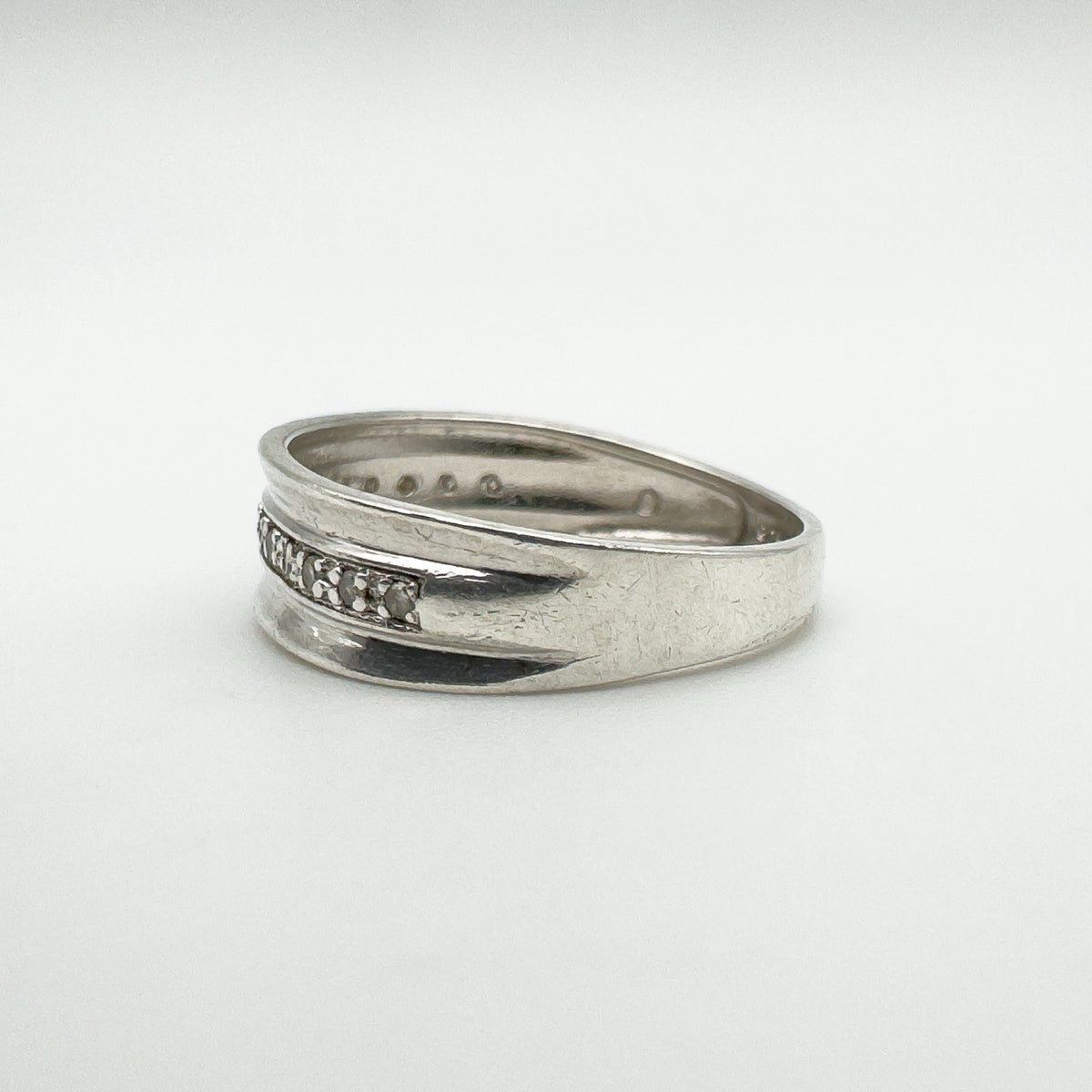 Side angle showing flush diamond setting and smooth concave design