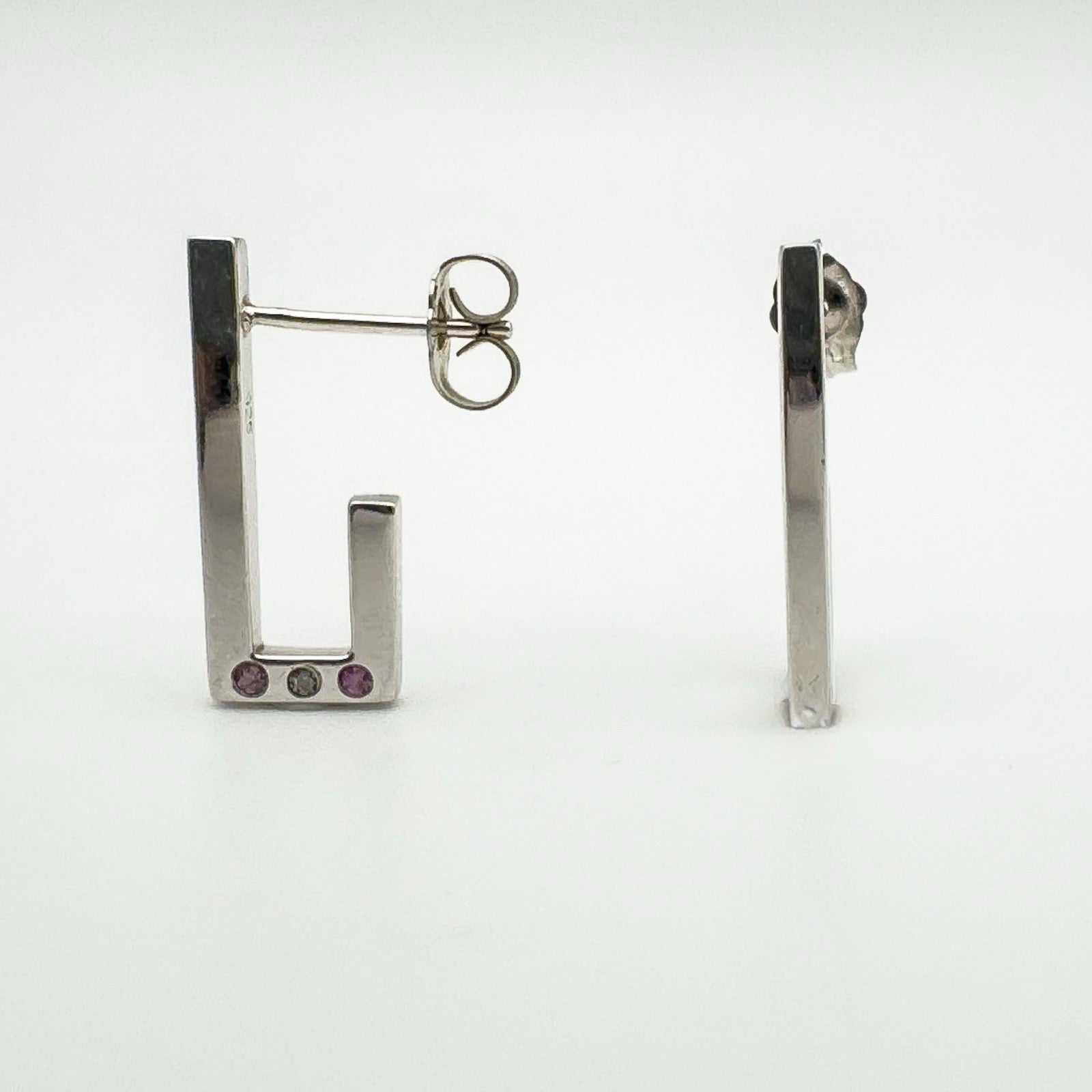 Side view of sterling silver J hoop earrings showing post and pink sapphire and diamond detail