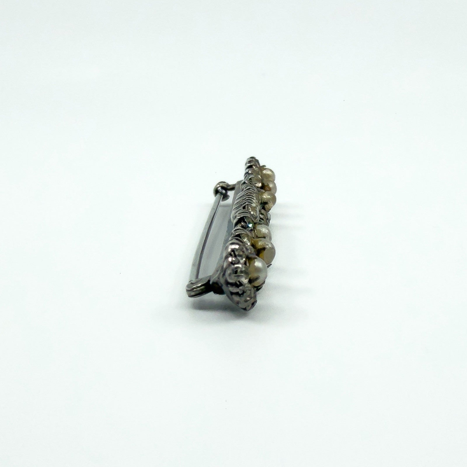 Side profile of antique sterling silver bar brooch showing the pin and clasp height.
