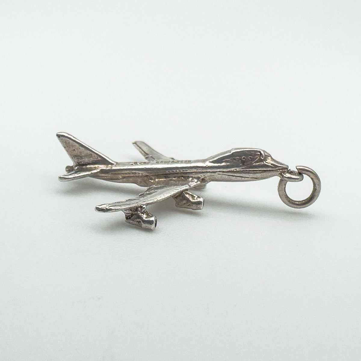 Side profile of the vintage aircraft pendant showing full body and wing detail