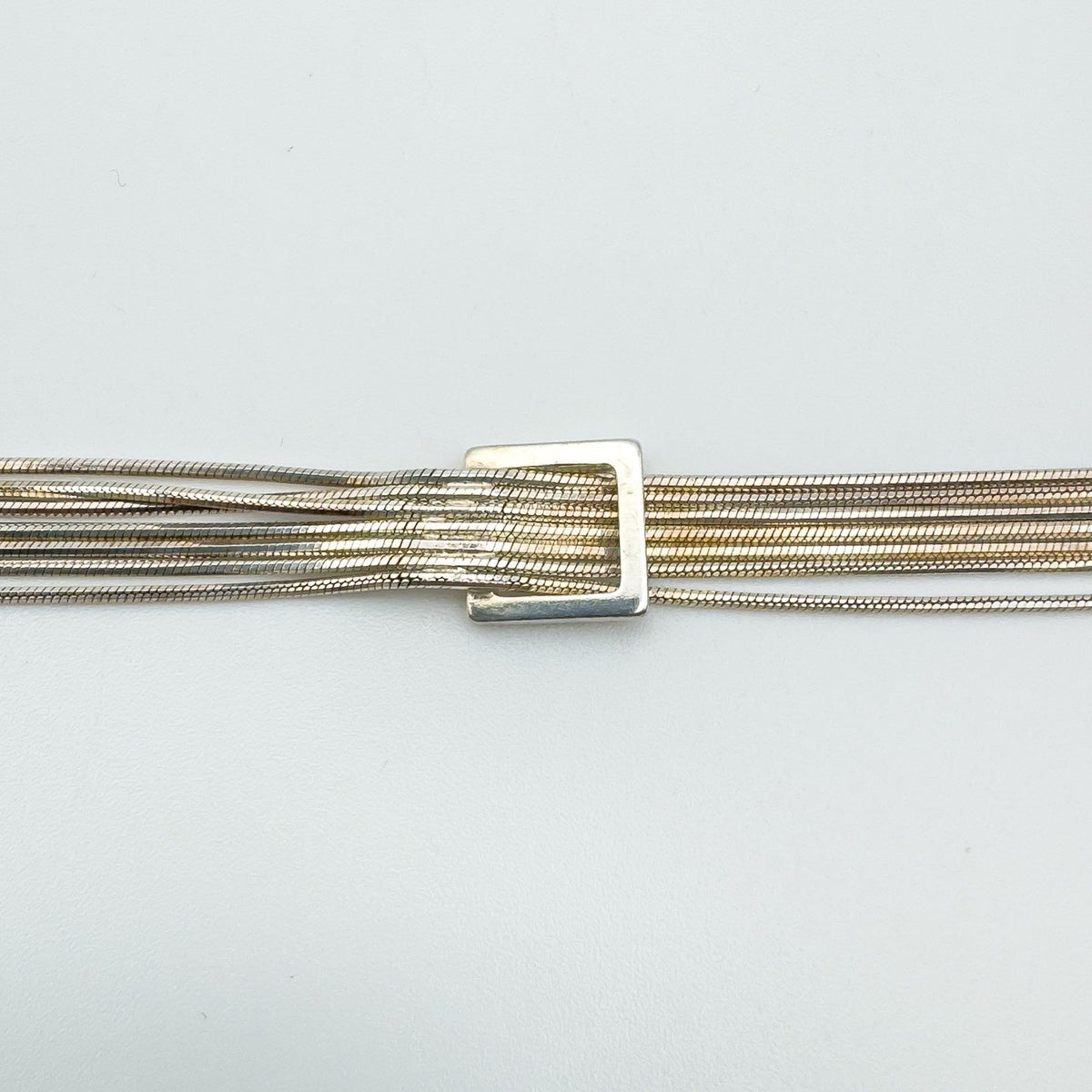 Close-up of square buckle on sterling silver snake chain bracelet