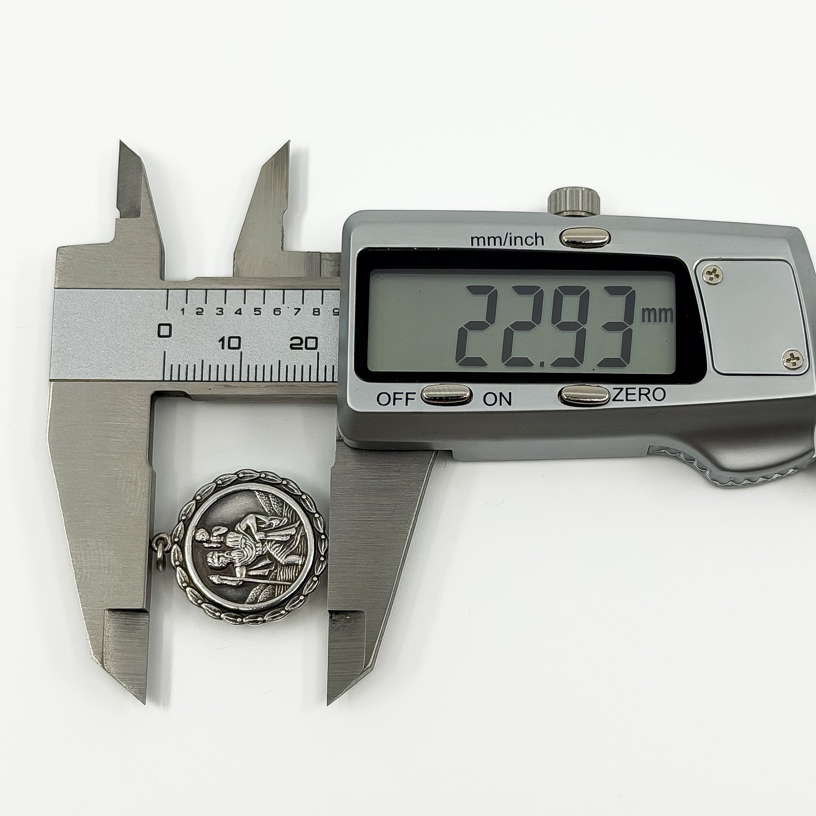 Digital caliper measuring the vintage sterling silver St Christopher pendant at approximately 22.93mm.
