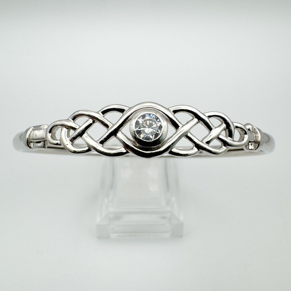 Celtic bangle with brilliant-cut CZ shown on clear display stand