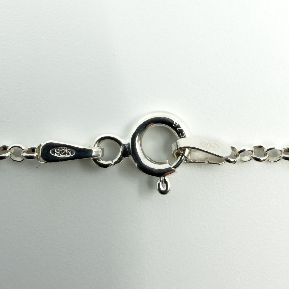 Close up of sterling silver chain clasp stamped 925 with spring ring fastening and fine chain links